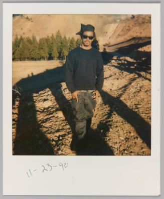 11-23-90 [Man standing in dusty landscape making hand gestures]