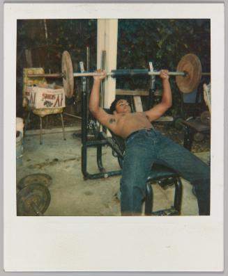 [Shirtless man lifting weights on a bench press]
