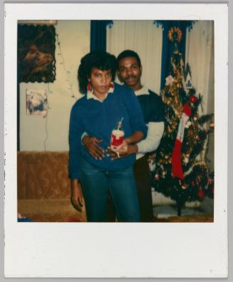 [Man holding woman around the midsection from behind with coke bottle in hand]
