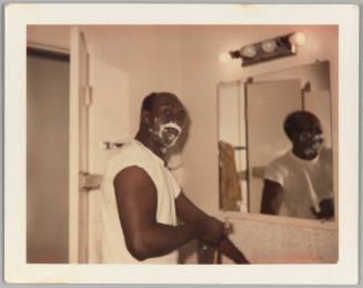 [Man shaving with shaving cream covered face]
