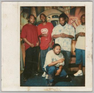 [5 young men posing with wine glasses and clasped hands] 
