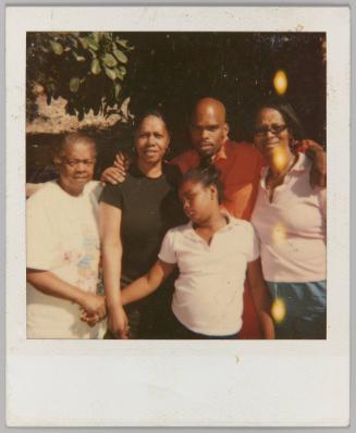 [Three women, man and girl posing together outside; elderly woman and girl holding hands]
