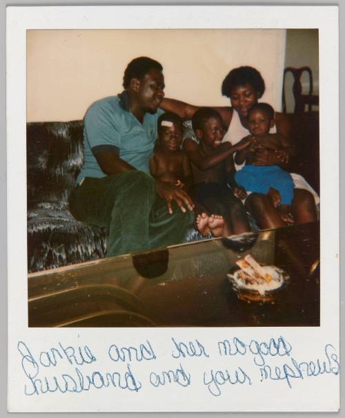 Jackie and her no good husband and your nephews [Man and woman sitting on couch with three young boys]
