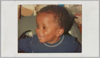 [Close-up of toddler smiling in blue thermal shirt]
