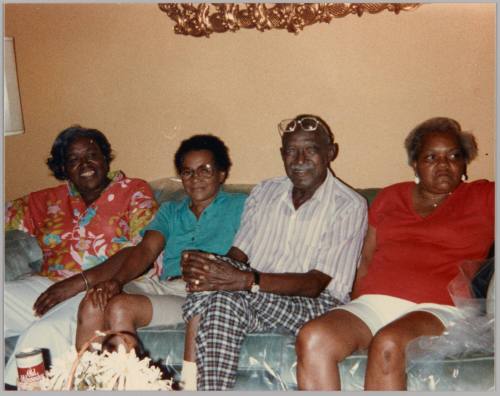 #18 [Four adults sitting on blue couch with plastic cover]
