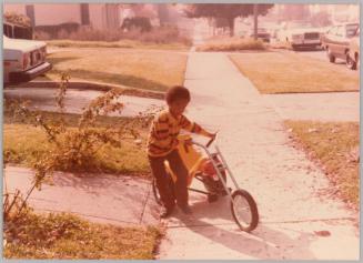 [Little boy pulling his bicycle]

