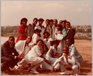 [Large group of young adults dressed formally in yellow field] 
