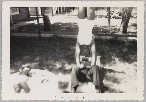 [Young woman balancing upside-down as young man holds her up]
