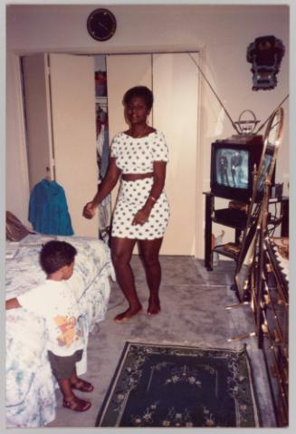 [Woman and child in bedroom with television turned on]
