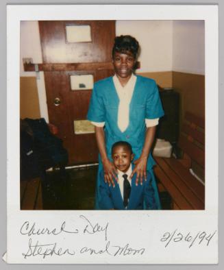 Church Day Stephen and Mom 2/26/94 [Woman in blue standing behind boy with her hands on his shoulders]
