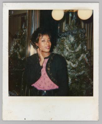 [Woman posing in front of Christmas Tree]
