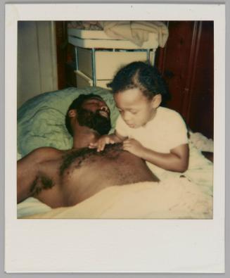 [Shirtless man asleep beside a child who is looking at and touching his chest hair]