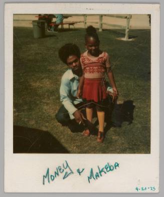 Money & Makeba 4-20-75 [Man sitting on grass with girl standing in front of him and wearing a pink top and skirt]