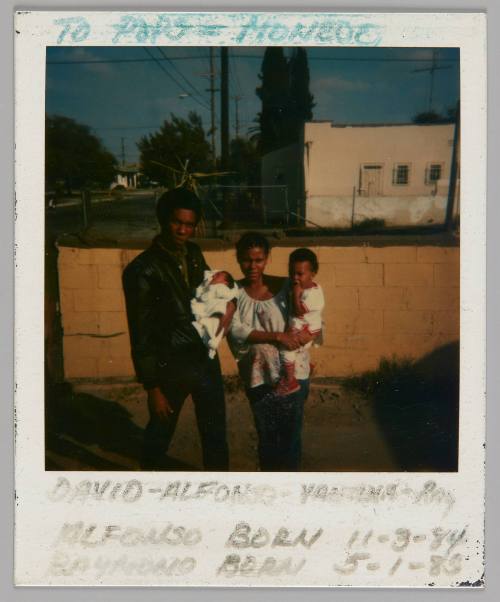 To Pops-Monroe, David - Alfonso - Vantina - Roy, Alfonso born 11-3-84 Raymond born 5-1-8[3?] [Man holding baby and woman holding toddler standing together outside]