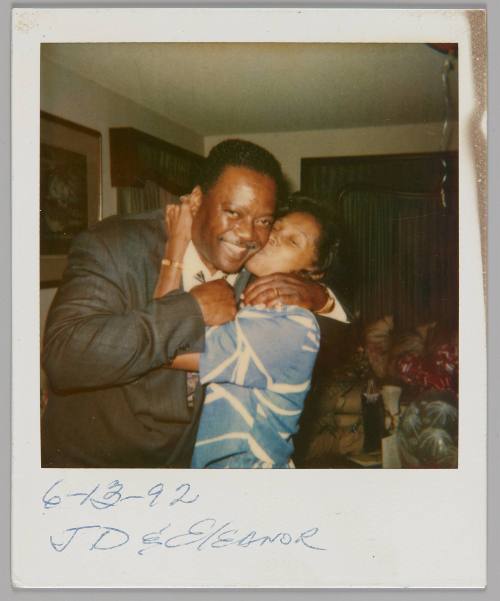 6-13-92 JD & Eleanor [Man in suit hugging woman in blue and white top who is kissing him on the cheek]