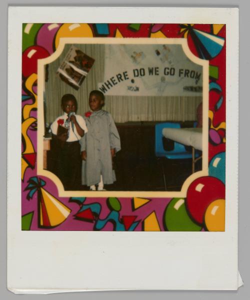 [Two children standing with red boutonnières, boy on left is holding microphone, behind them in a poster that reads "Where do we go from..."; a party-themed border surrounds the image]
