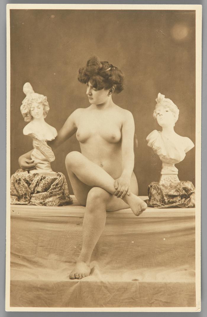 [Woman seated with sculptural busts]