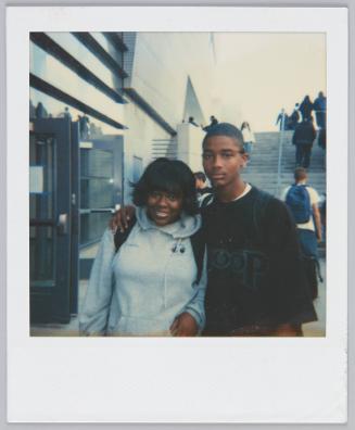 [Adolescent boy with arm around girl wearing a grey hoodie]