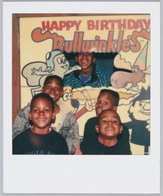 [Group of five little boys grinning, one stands behind "Happy Birthday Bullwinkle's" cutout]