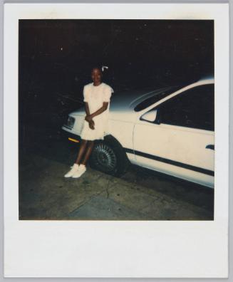 [Girl in white dress leaning against white car]