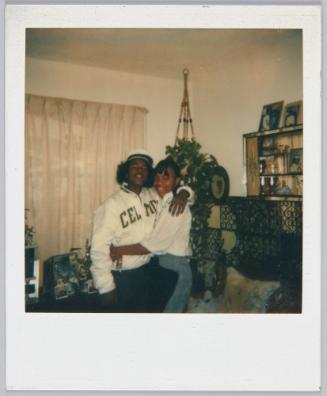 [Young couple with arms around each other, young man wears a Boston Celtics jacket]