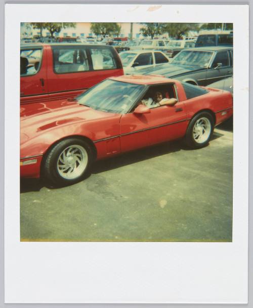 [Red sports car, woman in driver's seat]