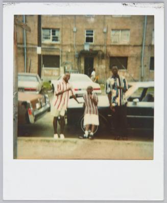 [Two young men posing on either side of boy, all wearing vertical striped shirts]