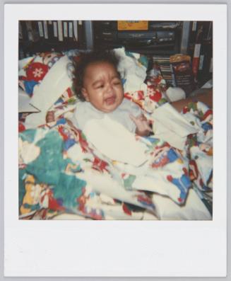 [Infant surrounded by blankets crying]