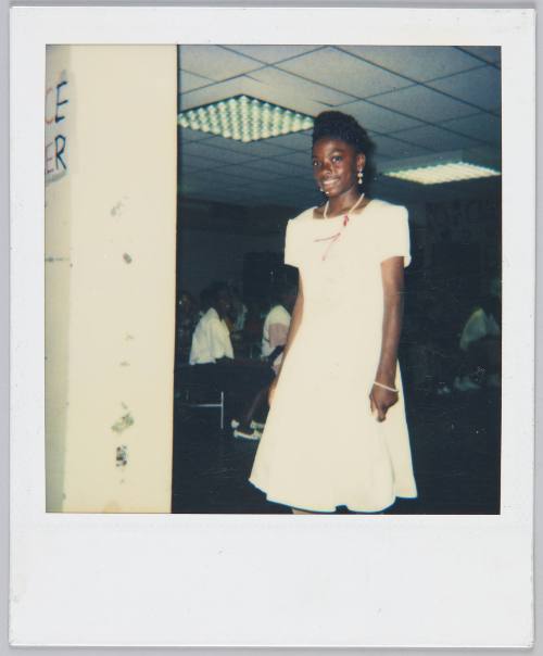 [Girl in white dress and dangling earrings smiling]