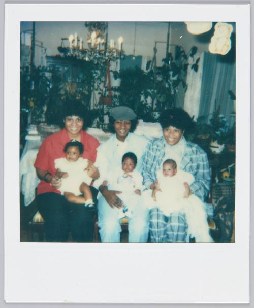[Three women sitting on couch with an infant in each of their laps]