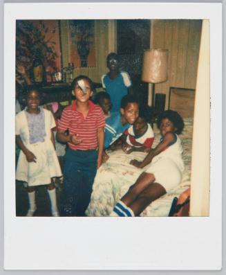 [Group of children hanging around in bedroom]