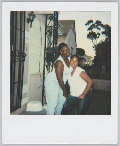 [Two women on porch, woman on left wears matching blue top and pants]