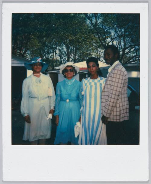 [Group of three women and man standing in formal attire]