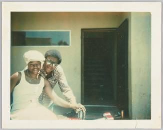 [Man wearing sunglasses standing behind woman in head-to-toe white]