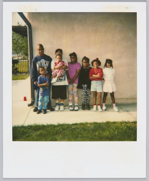 [Group of kids lined up again a wall, from tallest to shortest]