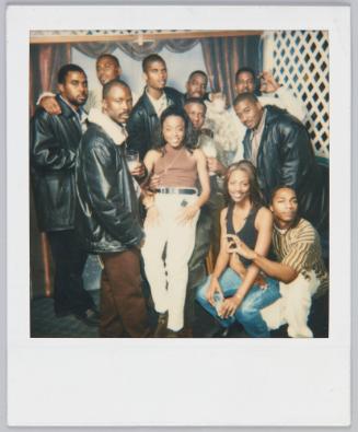 [Stylish group posing, woman in front wearing white pants and brown mock neck tank]