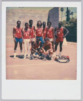 [Team of young men gathered on court wearing red 'Corn's Cavs' jerseys]
