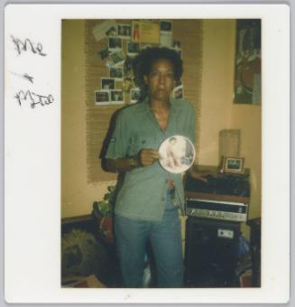 [Woman holding up circular pornographc image]
