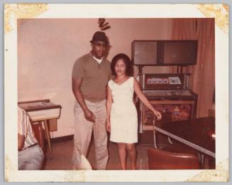 [Man and woman standin near jukebox, both their eyes are closed]
