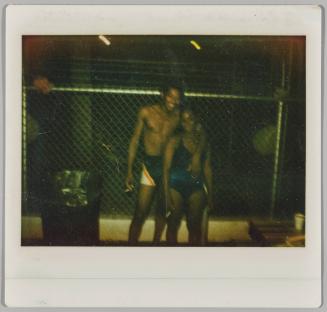 [Man with arm around woman in their swim suits at night]