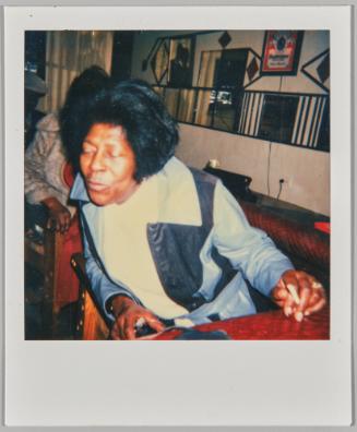 [Woman in unzipped blue jacket, she sitting and leaning forward with her eyes closed]