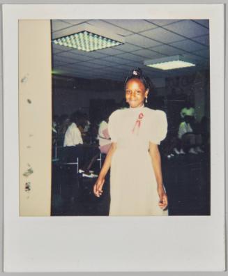 [Girl standing inside wearing a white dress with short puffed sleeves and a red ribbon]