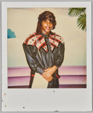 [Woman in bedazzled black leather jacket standing with her hands together]