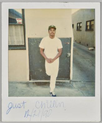 Just Chillin , 12/21/90 [Man in white shirt and pants leaning against wall outside]