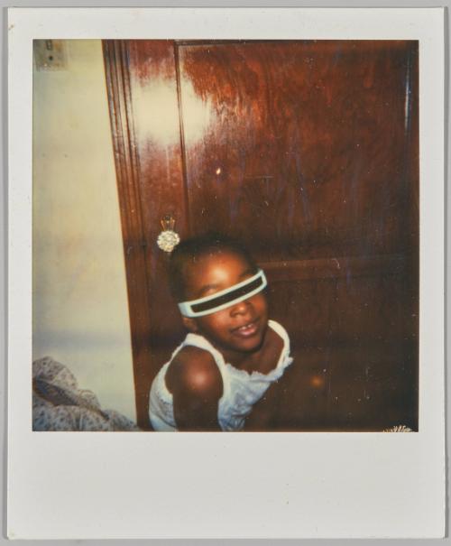 [Girl wearing costume sunglasses in front of wooden door]
