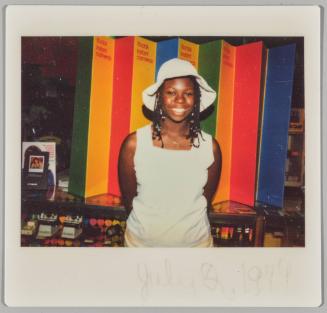 July 2, 1979 [Woman in white sunhat standing in front of signage for ‘Kodak Instant Camera’]

