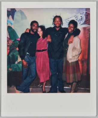 10 NOVEMBER 84 [Two men and two women standing with arms around each others shoulders in front of painted mural on back wall]
