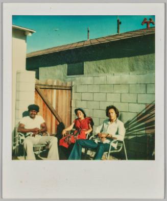 [Man in black wearing cowboy hat walking to right side of room, homemade silver fashion runway in background]
