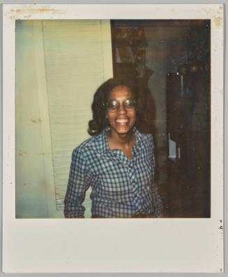 [Woman wearing glasses and plaid shirt smiling]
