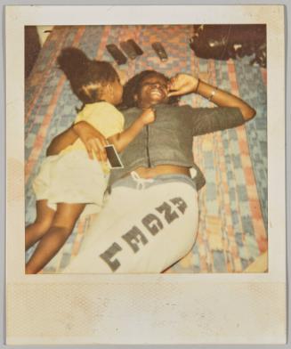 [Young woman laying on floor smiling, toddler girl lays next to her]
